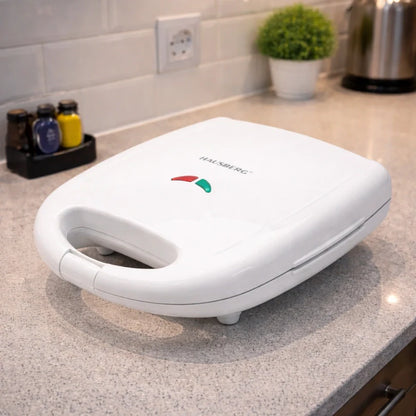 White sandwich toaster on a kitchen counter with visible brand name