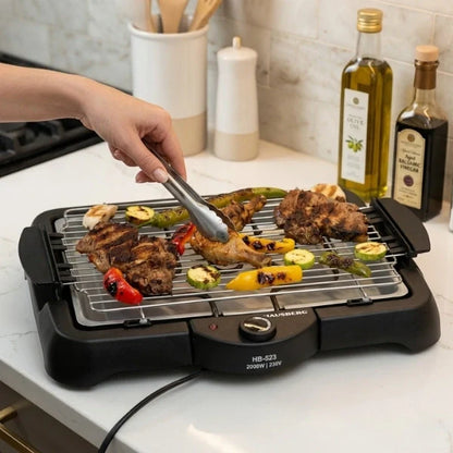 Person grilling food on a portable electric grill in a kitchen.